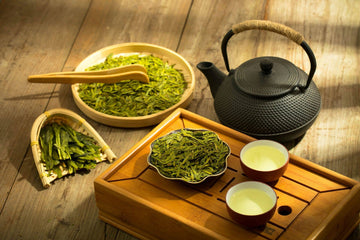 Green Longjing tea leaves with a tea kettle