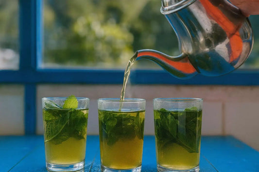 Fresh mint green tea being poured into glasses outdoors – refreshing herbal tea with spearmint leaves