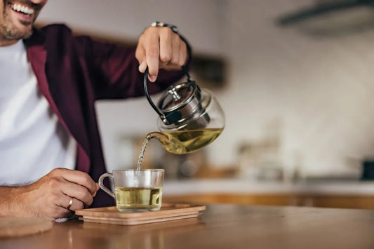 Pouring green tea into a glass cup—fasting-friendly, unsweetened.
