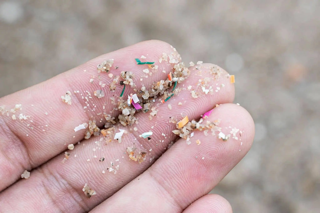 Close-up of microplastics on fingertips, illustrating plastic particles relevant to hot drinks and tea.