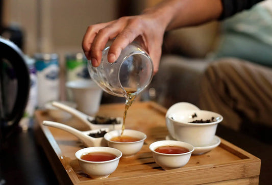 Hand pouring Himalayan Golden Nepali black tea using Gongfu-style brewing with ceramic teaware