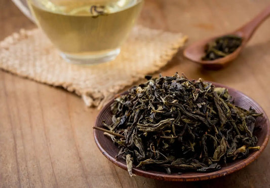 Black tea vs green tea: loose leaf Nepali green tea beside a brewed cup
