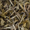 Detailed close-up of Ama Dablam white tea loose leaf featuring downy silver buds and large, intact green tea leaves.