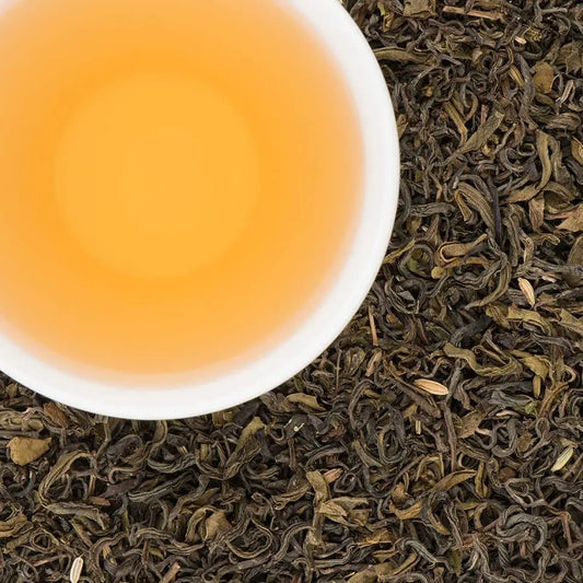 A steaming cup of brewed Makalu Mint green tea showing a clear golden infusion
