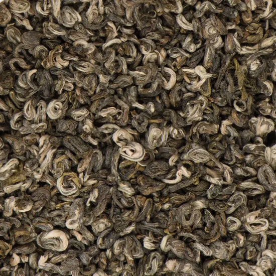 Dry loose-leaf Half Moon Pearl green tea from Nepal, featuring hand-rolled silvery buds and dark green leaves.