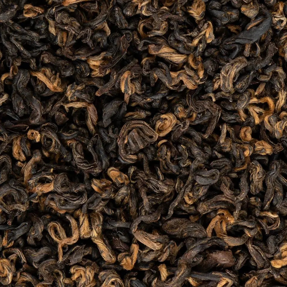 Close-up of high-quality Khumbu Organic black tea loose leaves showing golden tips and dark oxidation.