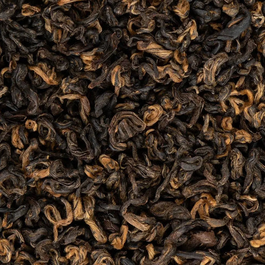 Close-up of high-quality Khumbu Organic black tea loose leaves showing golden tips and dark oxidation.