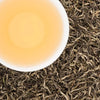 Brewed cup of Manaslu Spring Tippy black tea with a golden honey liquor and fuzzy silver-curled tips.