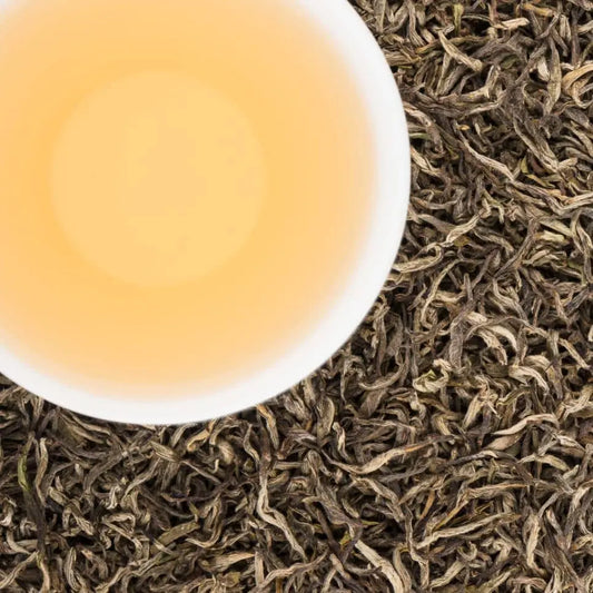 Brewed cup of Manaslu Spring Tippy black tea with a golden honey liquor and fuzzy silver-curled tips.