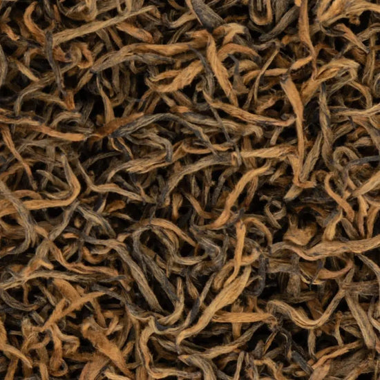 Macro shot of award-winning Sagarmatha Gold black tea leaves from Nepal, featuring signature golden tips and twisted texture.