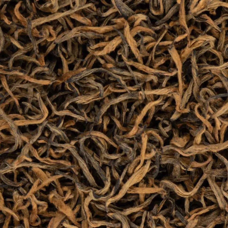 Macro shot of award-winning Sagarmatha Gold black tea leaves from Nepal, featuring signature golden tips and twisted texture.