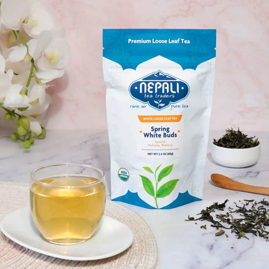 Spring White Buds organic white tea from Nepal—Nepali Tea Traders pouch with a brewed cup and loose leaves.