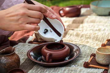 Traditional tea ceremony setup with loose leaf tea and clay teaware