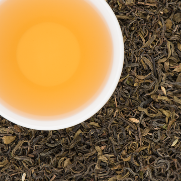 Brewed Makalu Mint tea in a glass cup, golden liquor